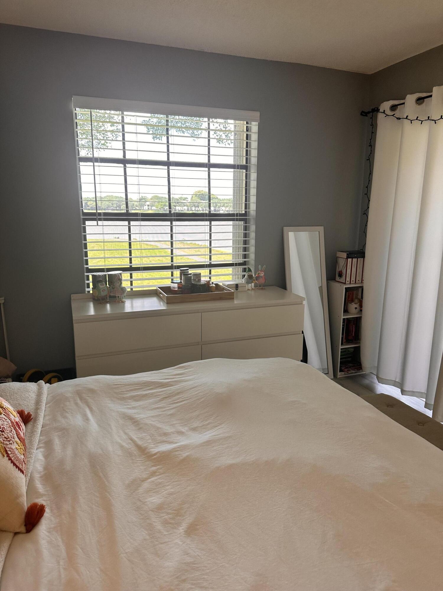 2800 Palmwood Terrace, Unit P221 Boca Raton, FL 33431 - Photo 9 of 16 a large bed sitting in a bedroom next to a window