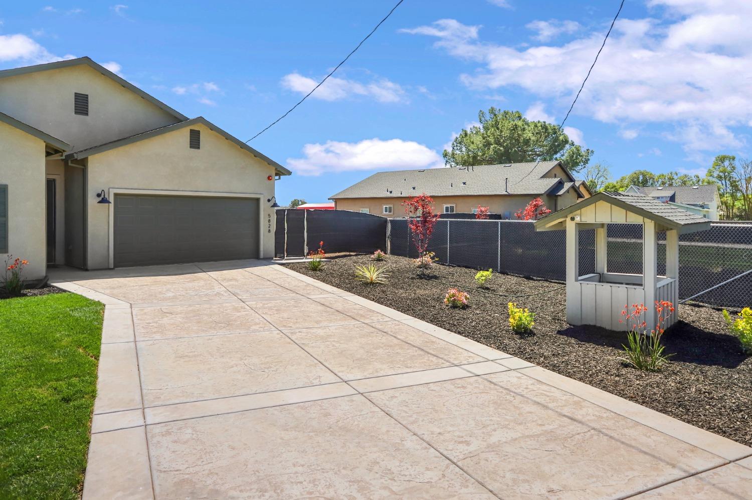 a front view of a house with a garden and outdoor seating
