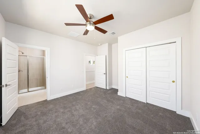 a view of a livingroom with a ceiling fan & entryway