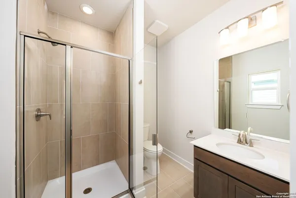 a bathroom with a shower sink vanity and mirror