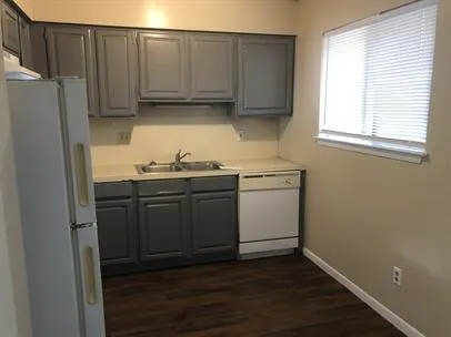 a kitchen with a sink a window and cabinets