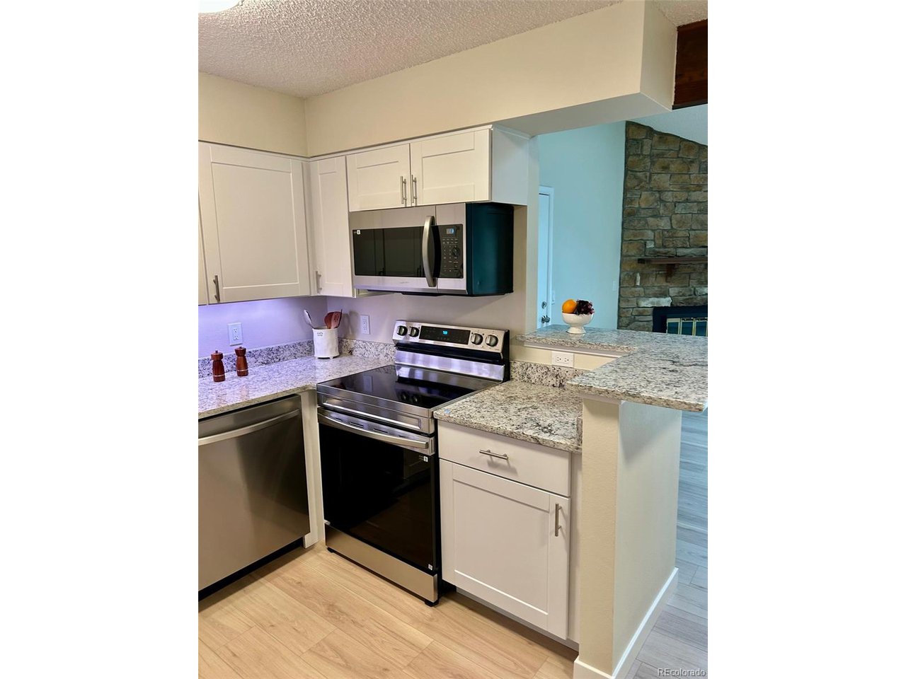 10251 West 44th Avenue, Unit 204 Wheat Ridge, CO 80033 - Photo 2 of 13 a kitchen with a stove and a microwave
