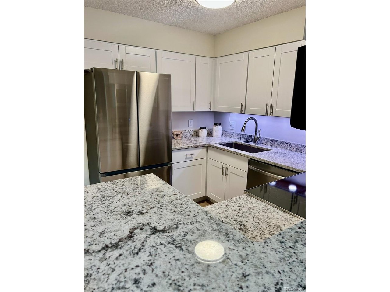 10251 West 44th Avenue, Unit 204 Wheat Ridge, CO 80033 - Photo 3 of 13 a kitchen with stainless steel appliances granite countertop a sink refrigerator and cabinets