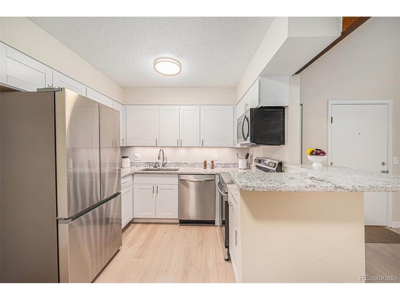 10251 West 44th Avenue, Unit 204 Wheat Ridge, CO 80033 - Photo 4 of 13 a kitchen with a refrigerator stove and sink