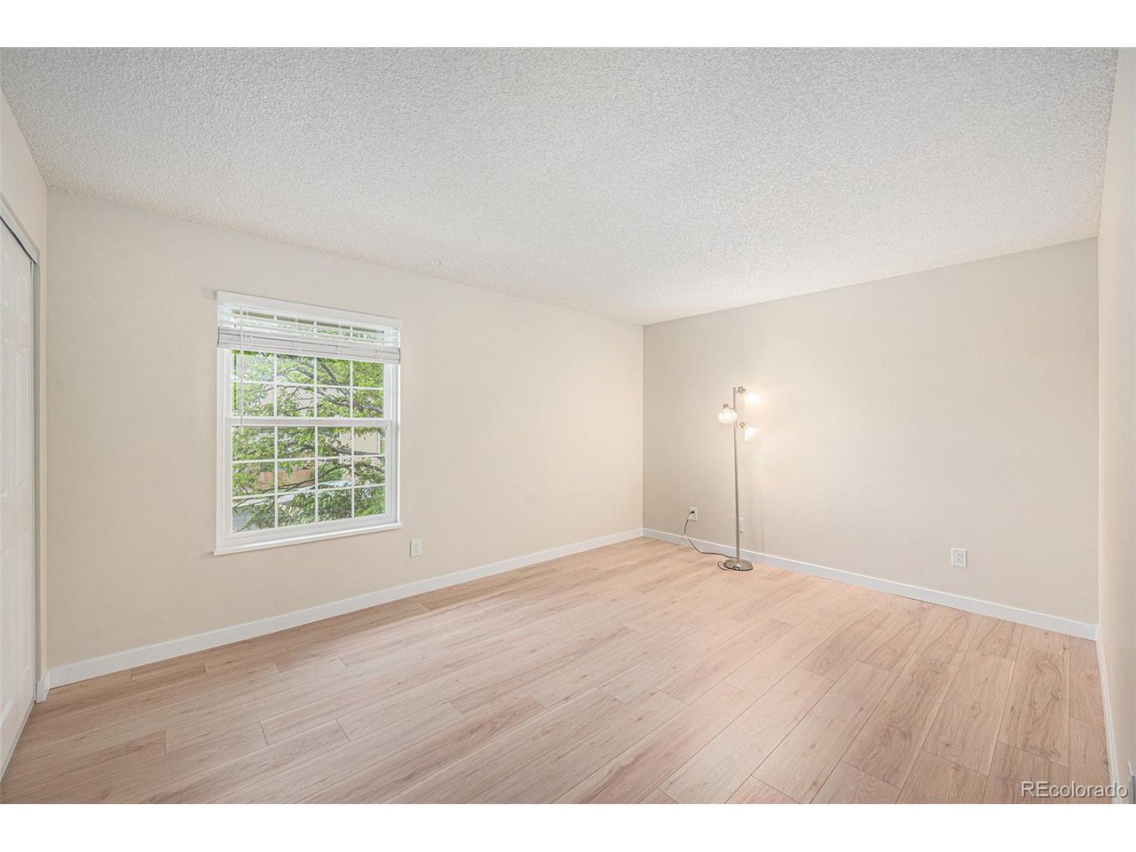 10251 West 44th Avenue, Unit 204 Wheat Ridge, CO 80033 - Photo 7 of 13 a view of an empty room with wooden floor and a window
