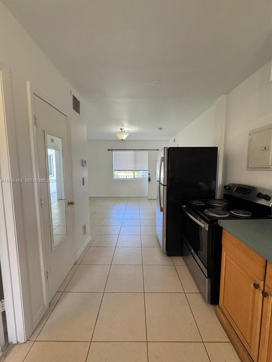 680 Northeast 88th Terrace, Unit 11 Miami, FL 33138 - Photo 8 of 8 a kitchen with a refrigerator and a stove top oven