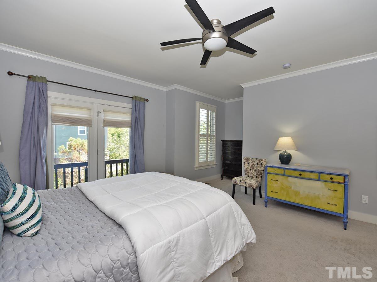 520 John Haywood Way, Unit 102 Raleigh, NC 27604 - Photo 12 of 18 a bedroom with a bed and a chandelier