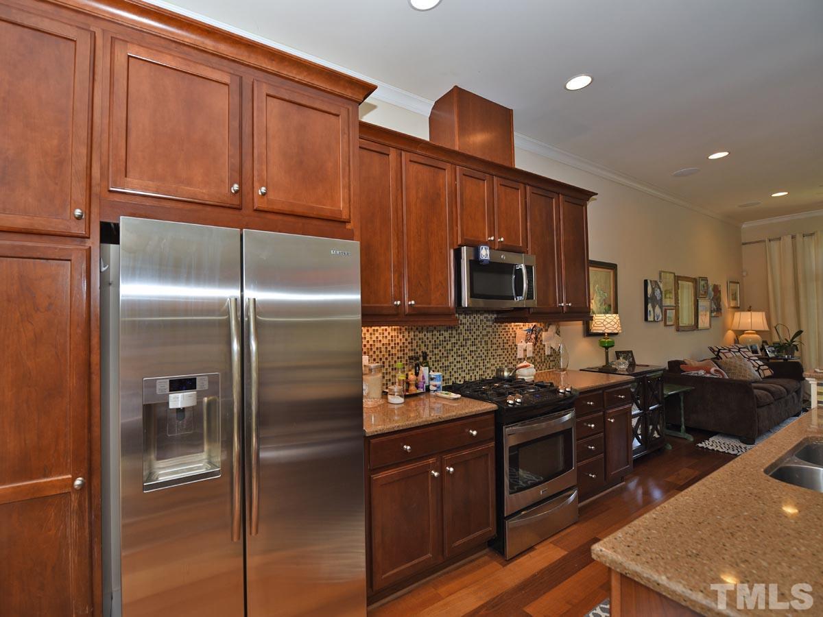520 John Haywood Way, Unit 102 Raleigh, NC 27604 - Photo 7 of 18 a kitchen with stainless steel appliances granite countertop a refrigerator and a stove top oven