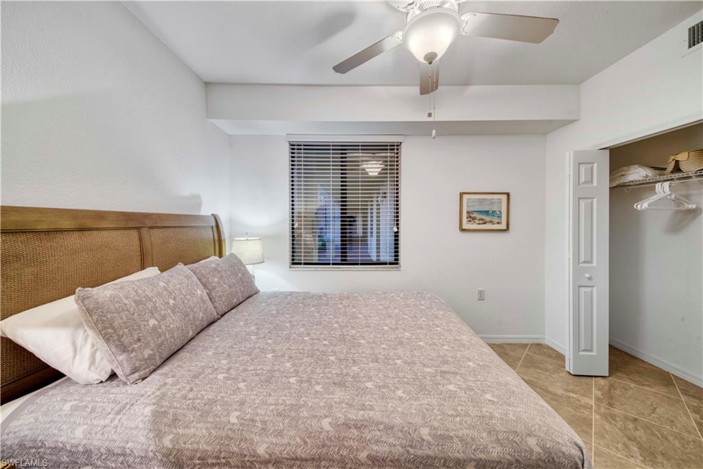 9572 Trevi Court, Unit 5017 Naples, FL 34113 - Photo 16 of 25 a bedroom with a large bed and a couch