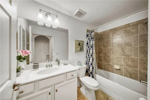 a bathroom with a sink a toilet a mirror a vanity and shower