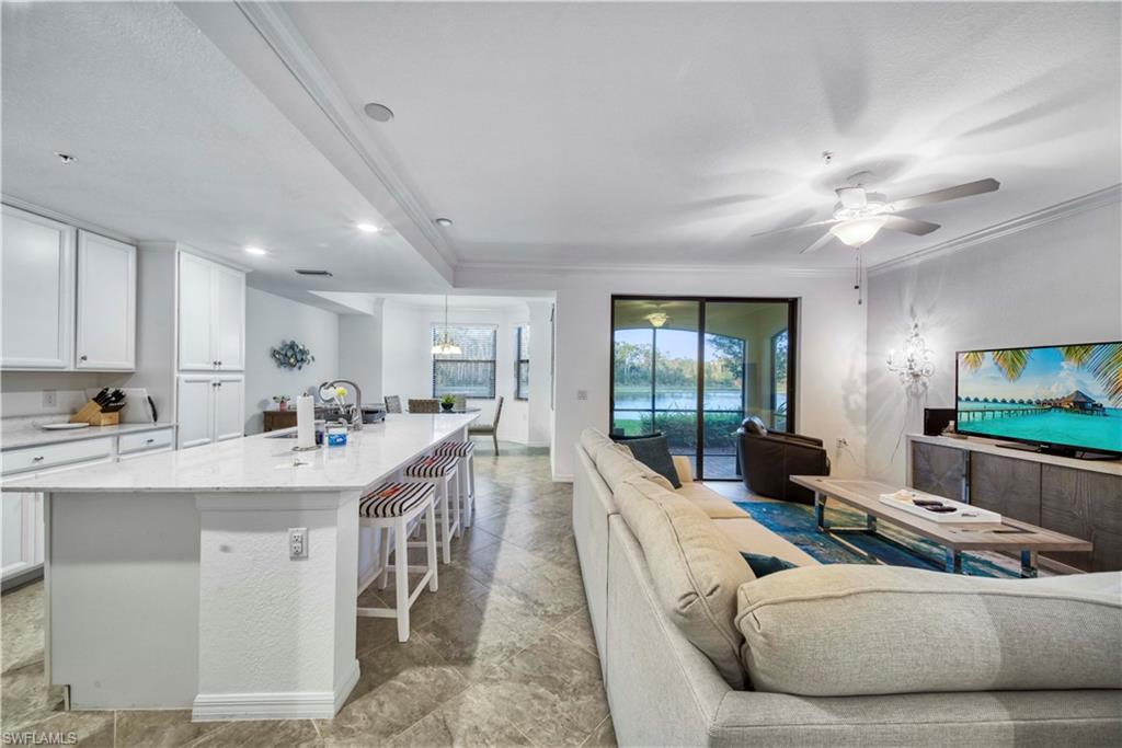 9572 Trevi Court, Unit 5017 Naples, FL 34113 - Photo 2 of 25 a living room with furniture and a flat screen tv