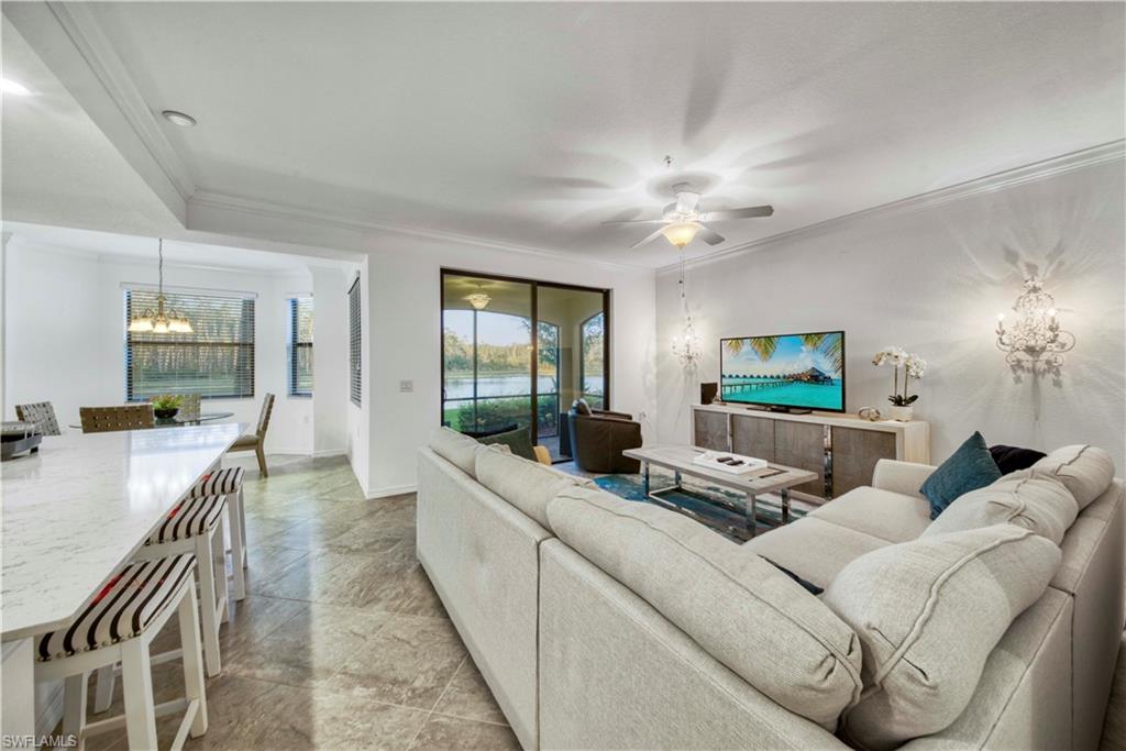 9572 Trevi Court, Unit 5017 Naples, FL 34113 - Photo 3 of 25 a living room with furniture a large window and a chandelier
