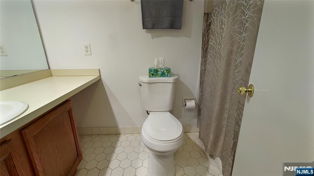 2210 Hilltop Road Mahwah, NJ 07430 - Photo 11 of 14 a white toilet sitting next to a sink and vanity