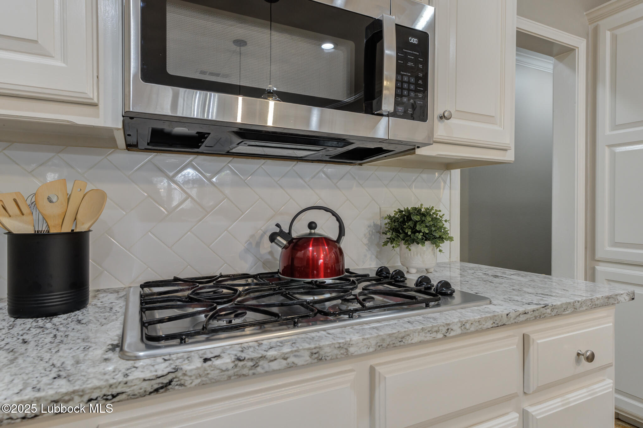 9406 Wayne Avenue Lubbock, TX 79424 - Photo 23 of 67 a kitchen with stainless steel appliances granite countertop a stove a microwave and cabinets