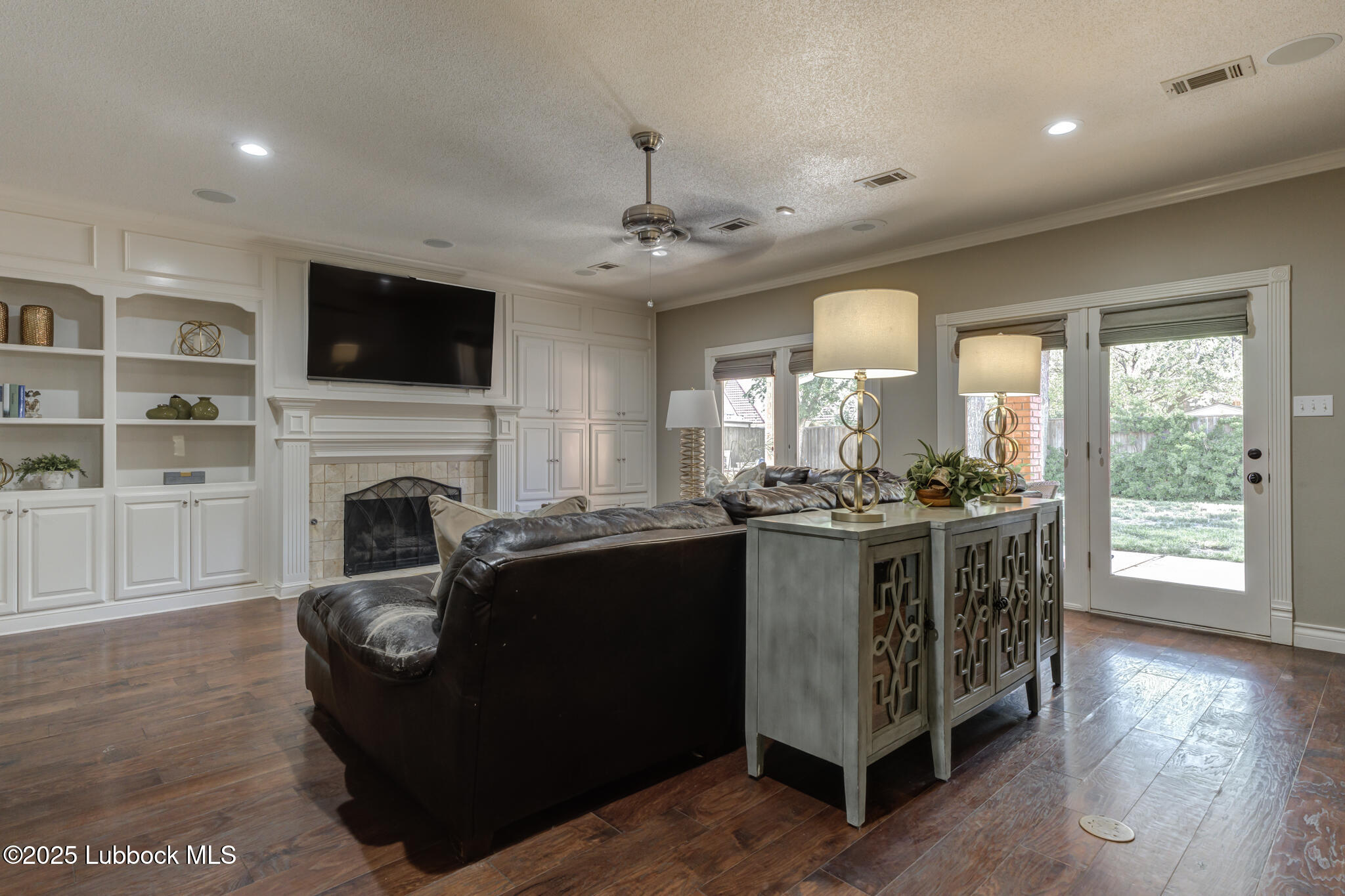 9406 Wayne Avenue Lubbock, TX 79424 - Photo 26 of 67 a living room with furniture a flat screen tv and a fireplace