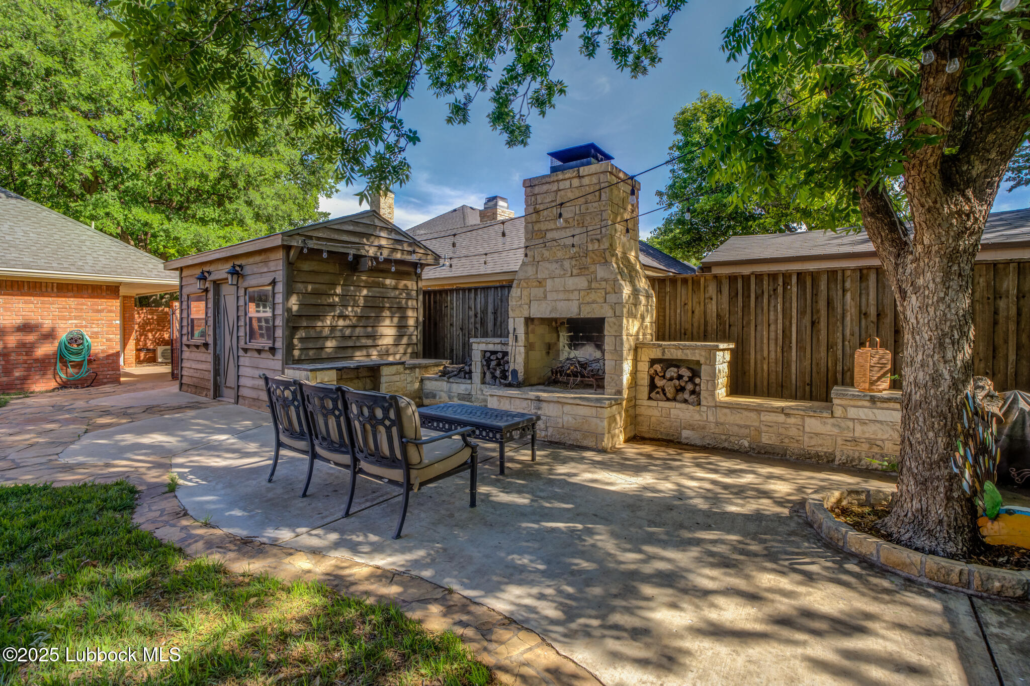 9406 Wayne Avenue Lubbock, TX 79424 - Photo 62 of 67 a view of a patio with table and chairs with wooden fence and plants