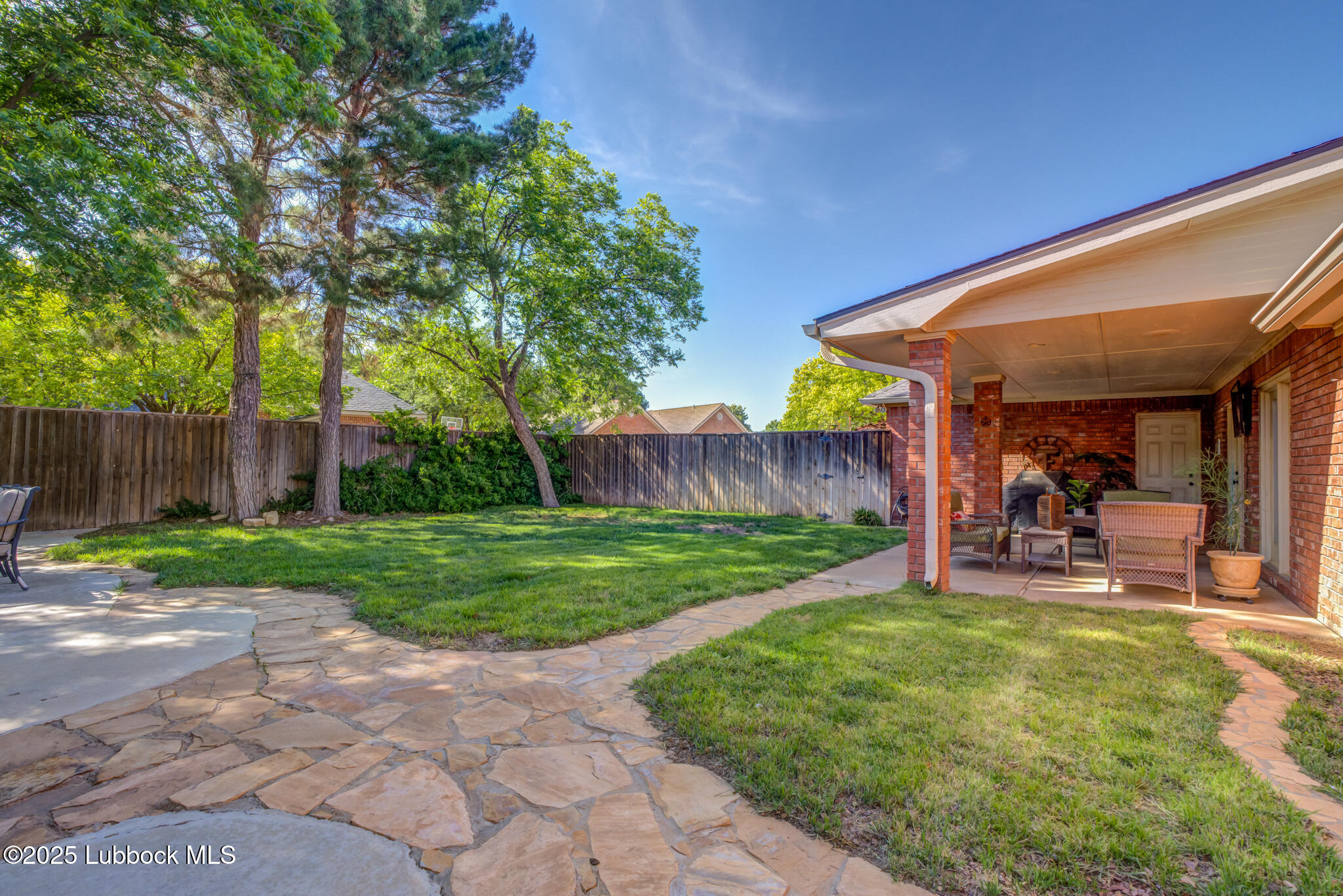 9406 Wayne Avenue Lubbock, TX 79424 - Photo 66 of 67 a view of a backyard with table and chairs and wooden fence