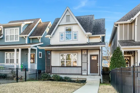 a view of a white house with large windows and a yard