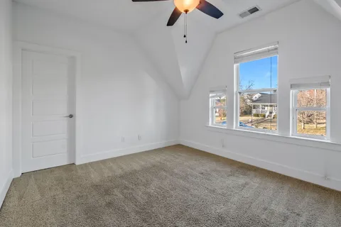 an empty room with chandelier fan