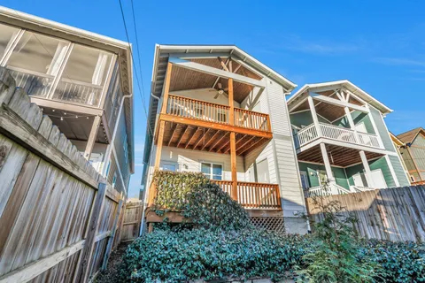 a view of a house with a small space and wooden deck