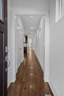 a view of a kitchen with a sink refrigerator and wooden floor