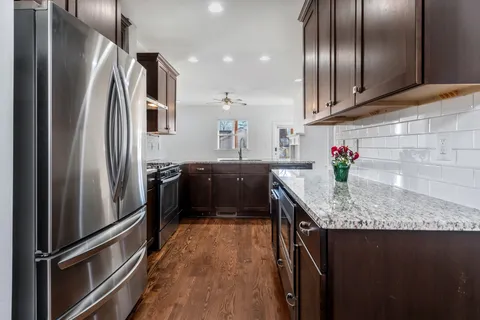a kitchen with granite countertop a refrigerator and a sink