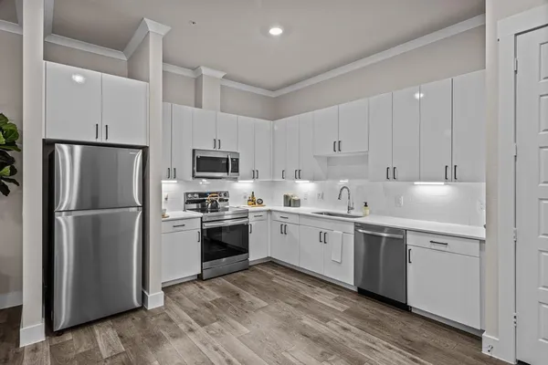 a kitchen with white cabinets stainless steel appliances and a sink