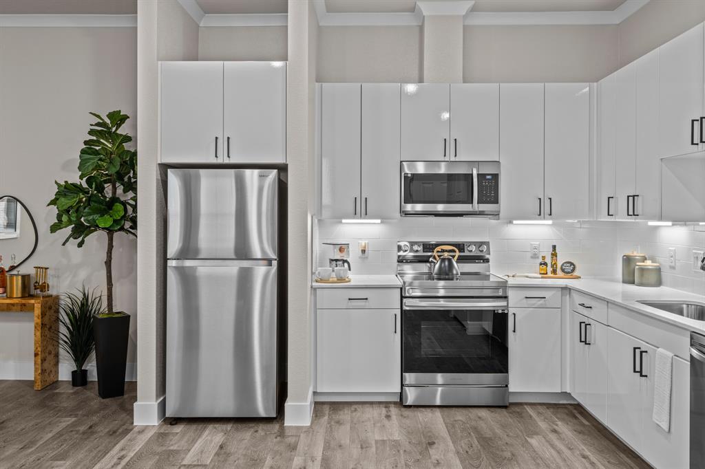 3277 Ganzer Road West, Unit 223A Denton, TX 76207 - Photo 11 of 32 a kitchen with stainless steel appliances a stove cabinets and a refrigerator