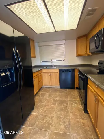 a kitchen with a sink a refrigerator and cabinets