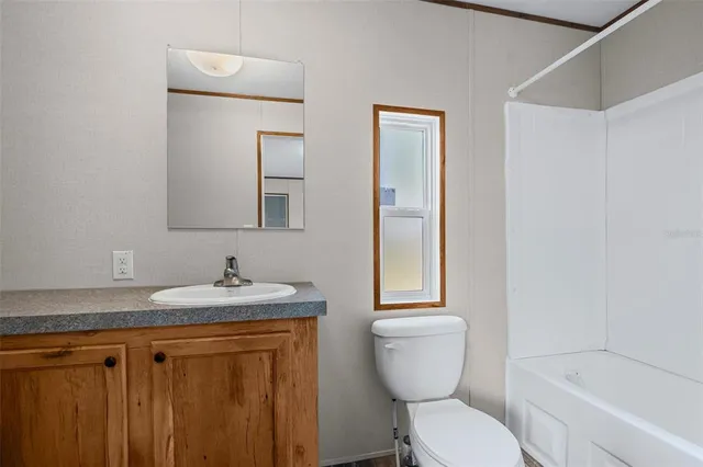 a bathroom with a granite countertop toilet sink and mirror