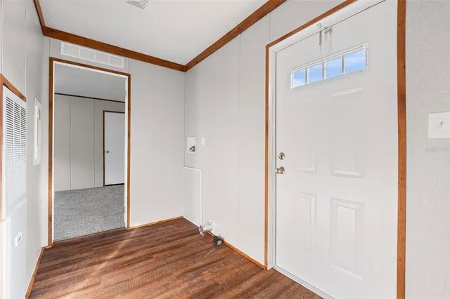 a view of a hallway with wooden floor and entryway