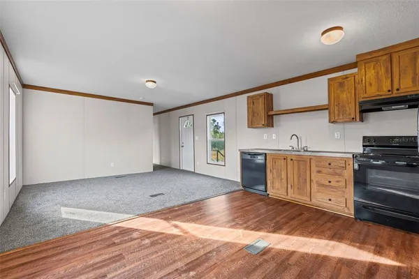 a view of kitchen with cabinets appliances and wooden floor