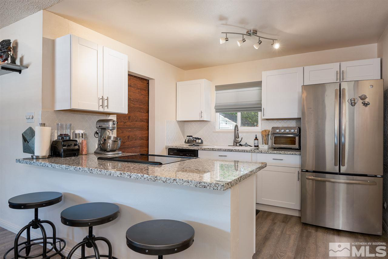 3425 Pierremont Road Reno, NV 89503 - Photo 17 of 28 a kitchen with stainless steel appliances granite countertop a sink refrigerator and cabinets