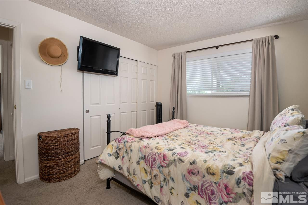 3425 Pierremont Road Reno, NV 89503 - Photo 27 of 28 a bedroom with a bed a flat screen tv and guitar