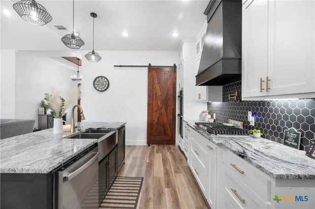 a kitchen with a counter space a sink and cabinets