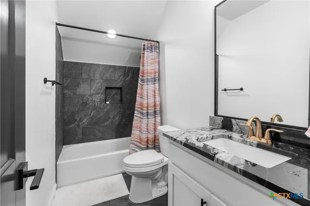 a bathroom with a granite countertop sink toilet and shower