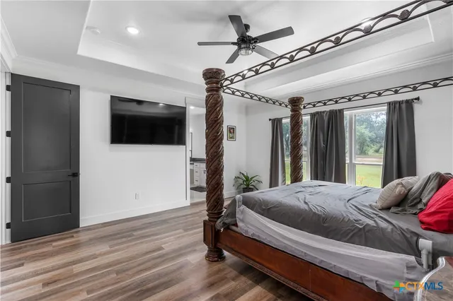a bedroom with a bed window and a flat screen tv