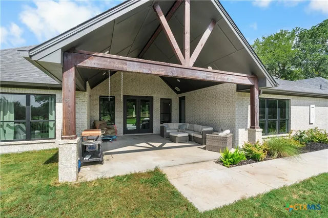 a patio with a table and chairs under an umbrella