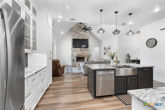 a kitchen with kitchen island a stove a sink and a refrigerator