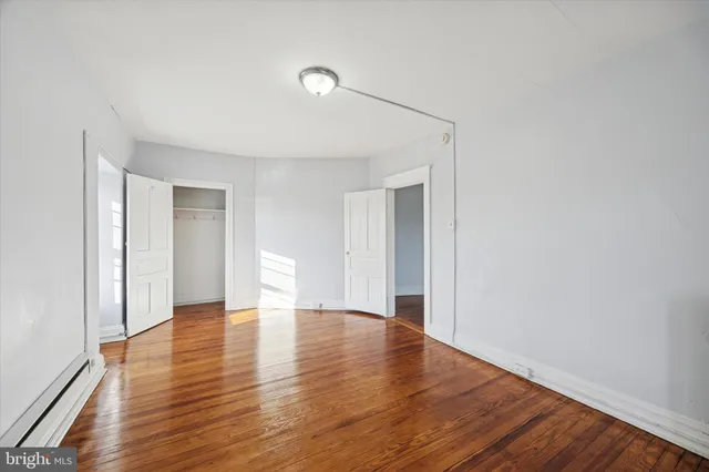 a view of an empty room with wooden floor