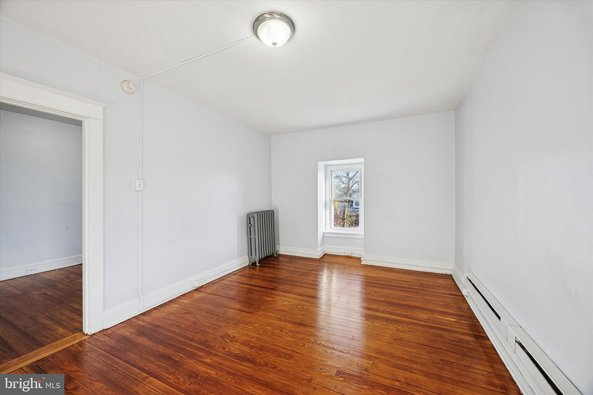 330 Kerlin Street, Unit 3 Chester, PA 19013 - Photo 4 of 15 a view of an empty room with wooden floor and a window