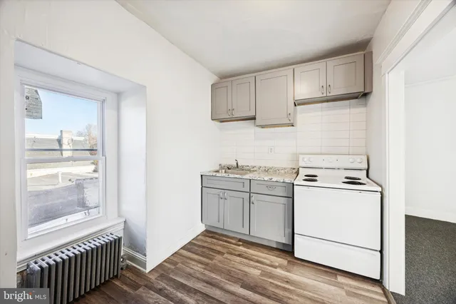 a kitchen with a sink a stove and cabinets