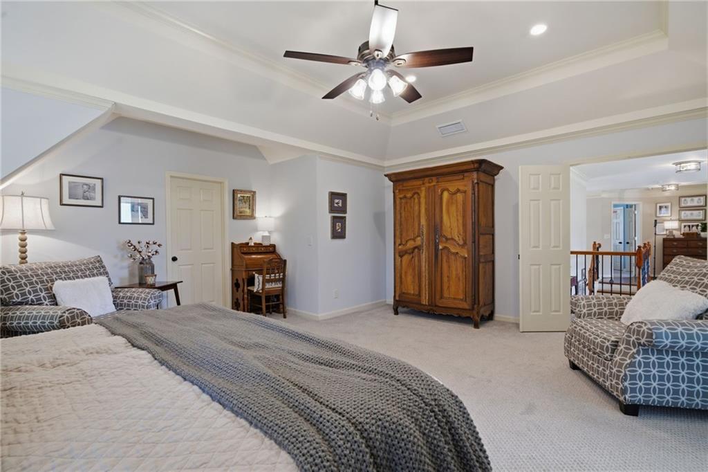 535 Brayford Way Suwanee, GA 30024 - Photo 29 of 55 a bedroom with a large bed and a chandelier