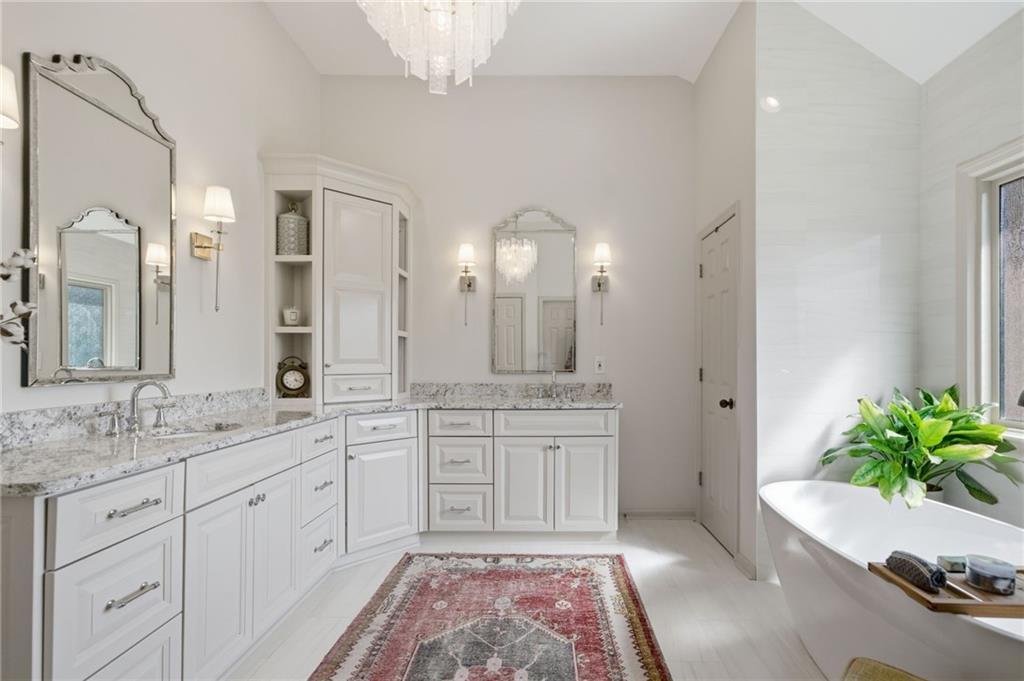 535 Brayford Way Suwanee, GA 30024 - Photo 31 of 55 a spacious bathroom with a granite countertop sink a large mirror and a bathtub