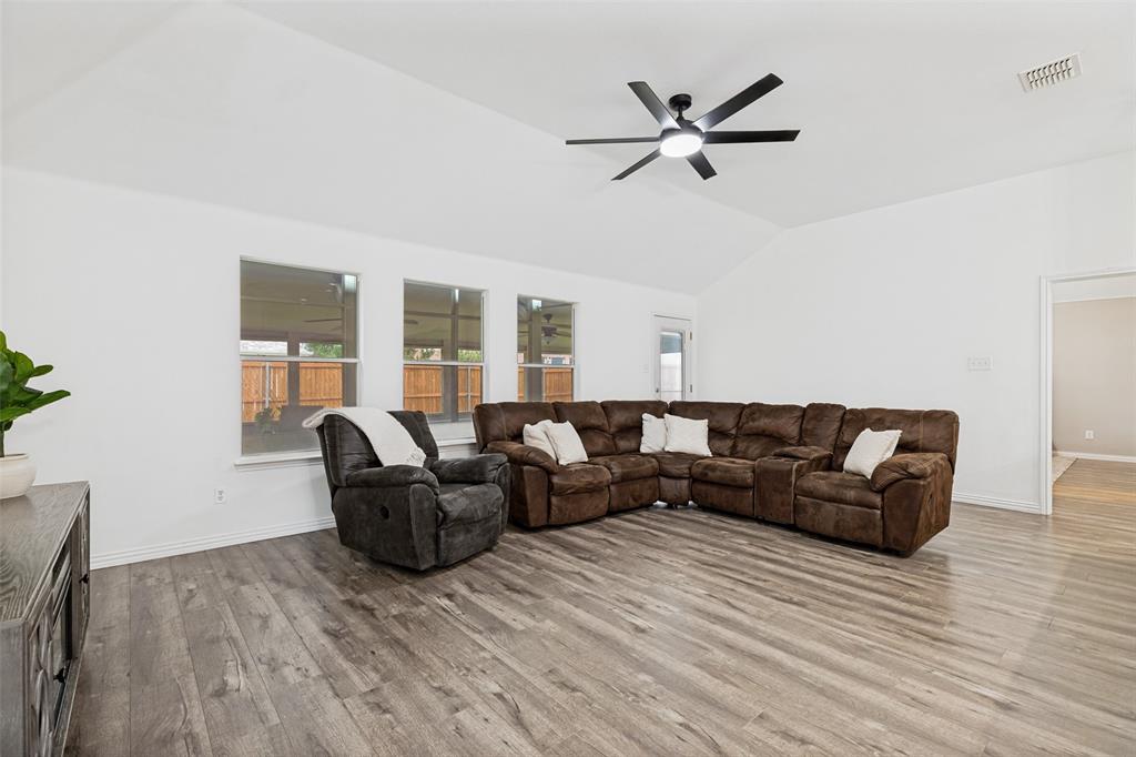 4305 Ridgewood Road Melissa, TX 75454 - Photo 5 of 26 Spacious living area featuring high vaulted ceilings, multiple windows, wood-finish flooring, and a contemporary ceiling fan