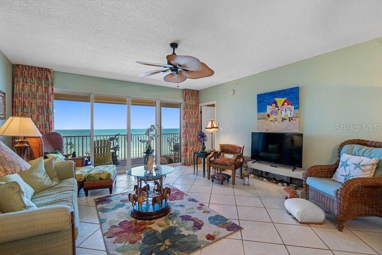 16550 Gulf Boulevard, Unit 545 North Redington Beach, FL 33708 - Photo 14 of 64 a living room with furniture a floor to ceiling window and a flat screen tv