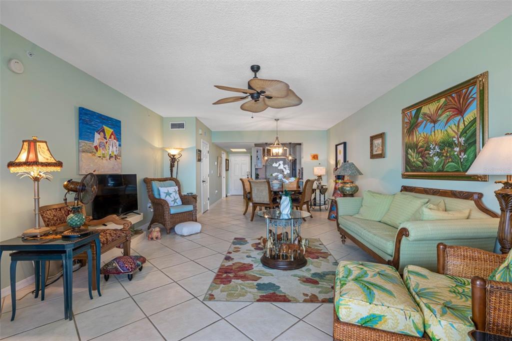 16550 Gulf Boulevard, Unit 545 North Redington Beach, FL 33708 - Photo 17 of 64 a living room with furniture a flat screen tv and paintings on the wall