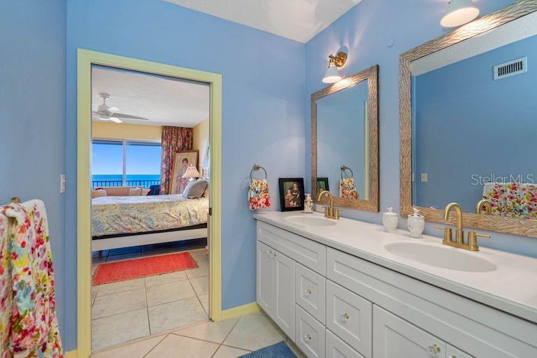 16550 Gulf Boulevard, Unit 545 North Redington Beach, FL 33708 - Photo 27 of 64 a en suite bathroom with a granite countertop sink and a mirror