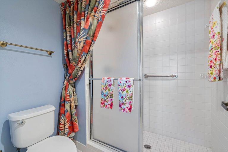 16550 Gulf Boulevard, Unit 545 North Redington Beach, FL 33708 - Photo 28 of 64 a white toilet sitting next to a shower curtain