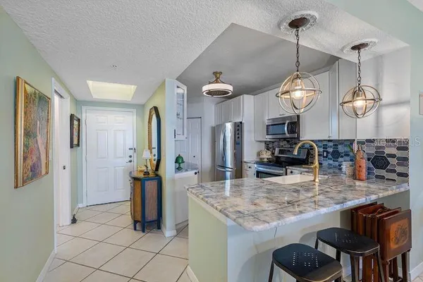 a kitchen with stainless steel appliances granite countertop a sink and a refrigerator